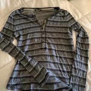 Long sleeve henley shirt. Black and gray pattern. Curved hemline on the bottom.